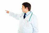 Medical doctor pointing finger in corner at copy space

