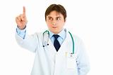 Serious medical doctor touching abstract screen
