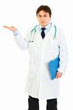 Authoritative doctor holding medical chart and presenting something 