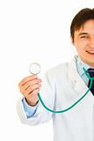 Smiling young medical doctor holding up stethoscope. Close-up.

