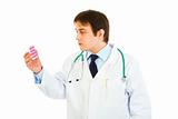Concentrated medical doctor looking on pills pack
