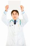  Medical doctor holding white paper over head
