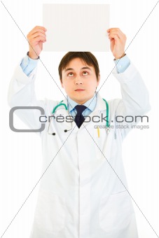  Medical doctor holding white paper over head
