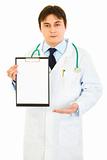 Authoritative medical doctor pointing at blank clipboard
