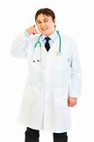 Smiling medical doctor showing contact me gesture
