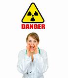 Concept- radiation danger! Medical doctor woman shouting through megaphone shaped  hands
