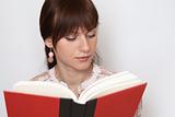 Young beautiful brunette reading a red book