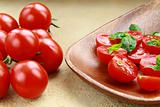 Tomatoes Cherry fresh ripe whole and sliced ​​on a plate