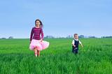 sister runing with her brather on the grass
