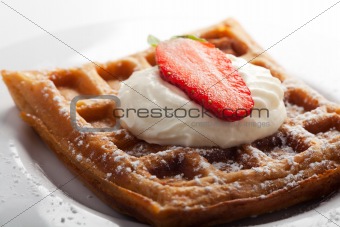 fresh waffle with cream and a strawberry