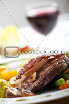bacon on a steak with vegetables