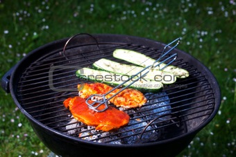 pork steak and zucchini on a grill outdoors