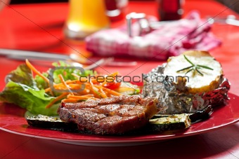 grilled pork steak on a plate outdoors