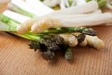 raw white and green asparagus on an oak table