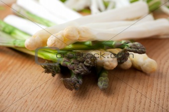 raw white and green asparagus on an oak table