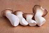 four king oyster mushrooms on a wooden table