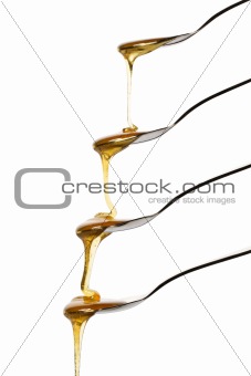 honey falling over four spoons