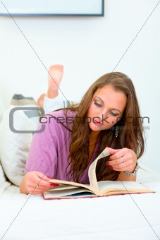 Young woman relaxing on sofa and reading  book
