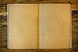 Brown notepad on the wood background