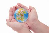 Child's hands holding jigsaw puzzle globe 