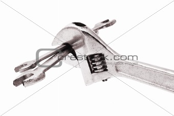 Adjustable wrench gripping a pair of spanners