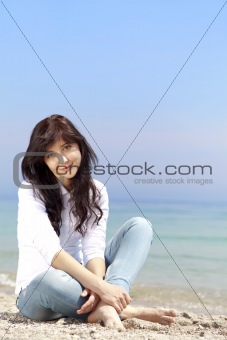 Young beautiful brunette girl at the beach in spring time. Outdo