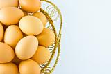 Chicken eggs in a basket on white background