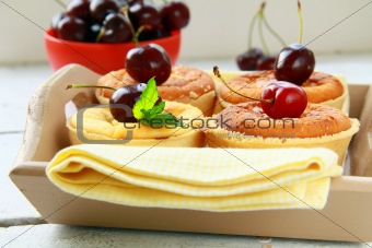 mini cheese cake with cherries and mint on a wooden table