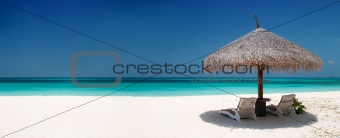 Beach Chairs and Umbrella on a beautiful island, panoramic view with much copy space