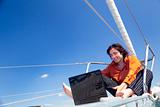 Businessman with laptop on sailboat