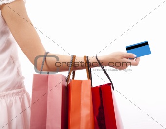 hand of woman holding shopping bags and credit card