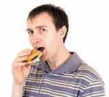 The young man eats a hamburger