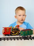 Little boy playing with a toy locomotive