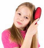 The beautiful girl brushes hair with a hairbrush