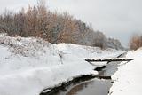 Winter river with a small bridge