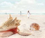 Beach scene with people walking and seashells