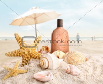 Suntan lotion and seashells on the beach