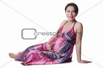 A pregnant woman lies in a beautiful dress