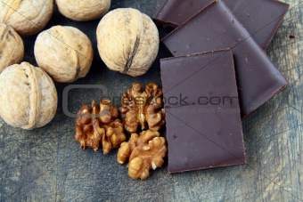 walnuts and dark chocolate on a wooden background