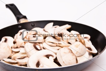 sliced mushrooms on black plate frying pan