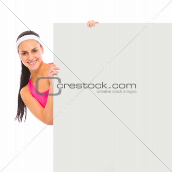 Smiling young girl looking out from blank billboard
