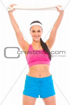 Enjoying making sports young girl holding towel over her head
