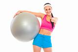 Smiling fit young girl with fitness ball showing thumbs up gesture
