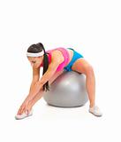 Young girl doing stretching exercises on fitness ball
