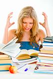 Frustrated teen girl with lots of books tired of studying

