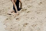 Young girl sits in sand