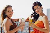 two girls on holidays in Cuba, holding cocktails  