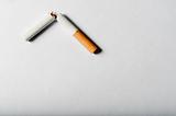 Broken cigarette on white background with harsh shadows