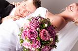 young couple in wedding wear with bouquet of roses