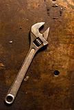 Adjustable wrench on rusty metal plate